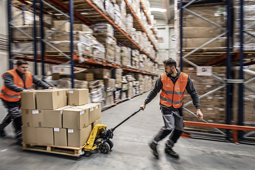 Workers transporting boxes in warehouse